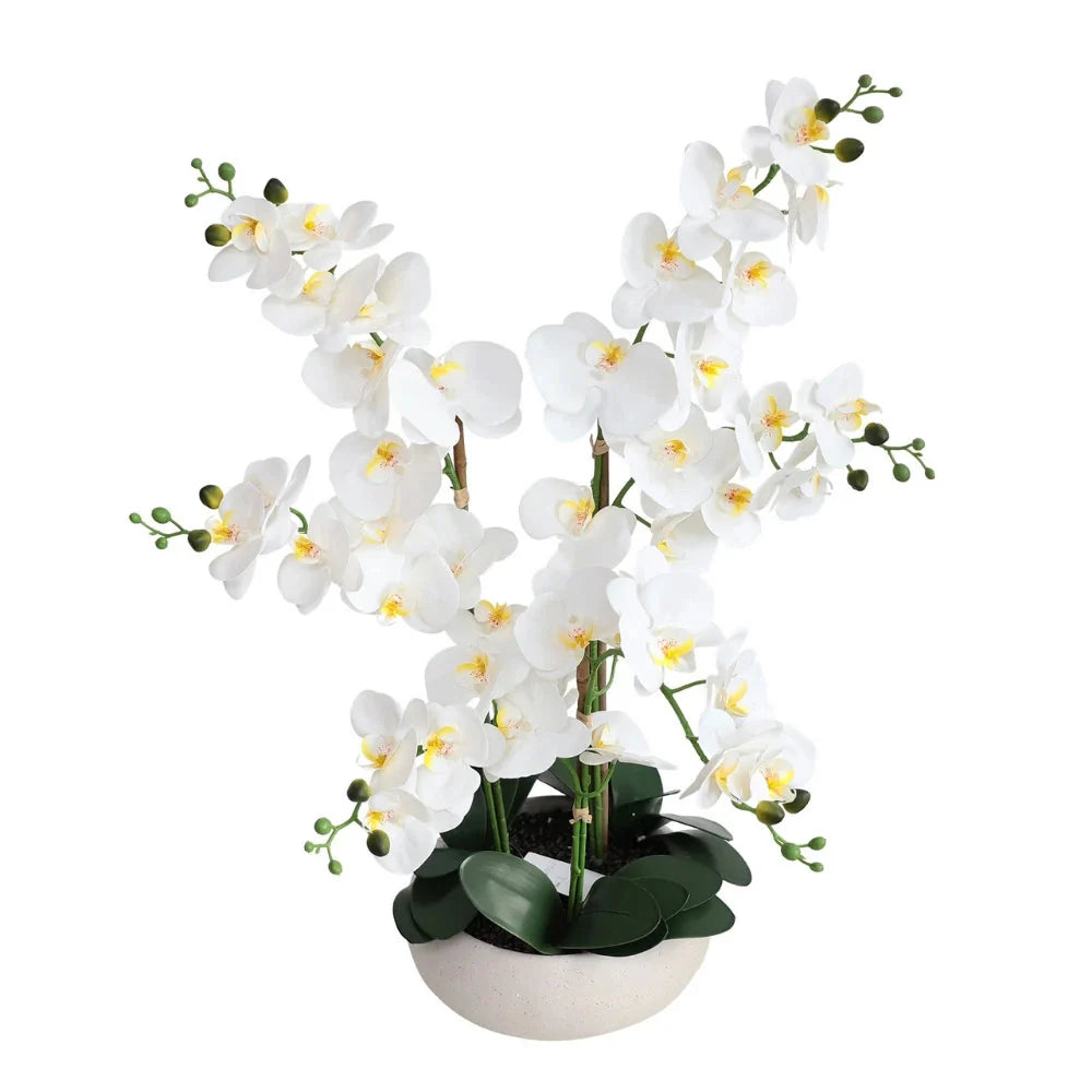 Artificial white phalaenopsis orchid on a bathroom vanity beside the basin